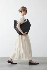 Falda larga plisada color marrón, de silueta amplia y caída fluida.