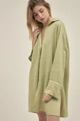 Camisola color verde pistacho, de corte holgado, confeccionada en lino y tencel. Tiene cuello camisero, mangas largas con puños abotonados, cierre frontal con botones y bolsillos laterales.