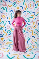 Pantalón sastrero de corte amplio y tiro alto, color rojo vibrante. Presenta pinzas en la cintura, cierre frontal con botón a la vista y diseño de pierna ancha.