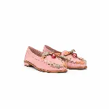 Mocasín plano de cuero color rosado, con punta redondeada y taco bajo. Presenta un detalle artesanal de tiras entrelazadas en tonos nude, verde y rosado alrededor del empeine, rematado con un aplique colgante central con piedra transparente.