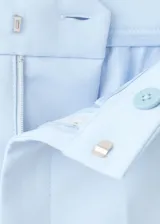 Pantalón de traje color celeste de tiro medio y diseño recto, con bolsillos laterales y cierre oculto.