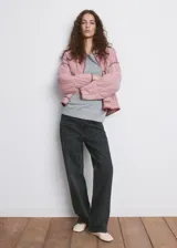 Chaqueta oversize acolchada de color rosado con diseño pespuntado en zigzag, cuello camisero, manga larga, bolsillos delanteros de parche y ribetes en contraste.