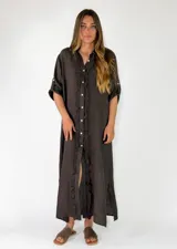 Vestido midi marrón oscuro con botonadura frontal completa, cuello redondo y detalles de volados a lo largo de la botonadura, de manga corta con trabilla.