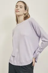 Sweater de tejido de punto color lavanda, de corte holgado y cuello redondo.