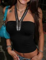 Top negro ajustado de escote fruncido con tiras halter cruzadas al cuello, decoradas con tachas metálicas plateadas.