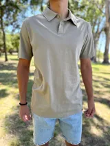 Remera chomba de manga corta en color cemento, con cuello polo y cierre frontal con botones.