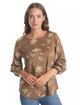 Blusa de tejido fino color marrón con bordado floral en hilo dorado. Presenta cuello redondo, mangas tres cuartos abullonadas con puños elásticos fruncidos y ruedo redondeado con corte asimétrico.