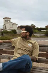 Remera gris con efecto gastado, de manga corta y corte holgado. Estampa en el pecho con un sol, una ola y la frase 'Life is Better'.