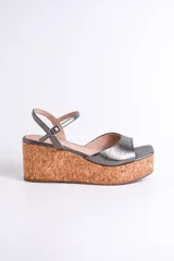 Sandalias plateadas con plataforma de corcho, tira delantera ancha y tira fina con hebilla alrededor del tobillo.
