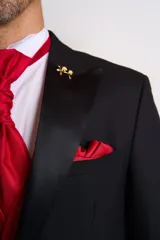 Ambo de ceremonia compuesto por saco negro con solapas de satén, chaleco rojo satinado, camisa blanca, corbatín rojo y pantalón de vestir negro a juego.