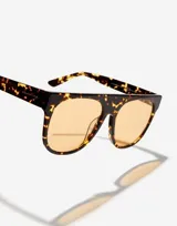 Lentes de sol unisex Hawkers modelo La Noire Eco, con montura carey y lentes color naranja.