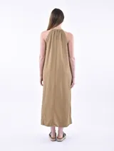 Vestido largo tostado de corte holgado, con cuello halter fruncido, sin mangas y bolsillos laterales.