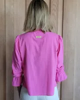 Blusa de algodón con cuello mao y volados, mangas largas con puños elásticos y corte holgado.