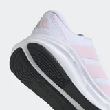 Championes de running Adidas modelo Galaxy 7, color blanco con detalles en rosado claro en las bandas laterales y suela negra. Presentan una parte superior de malla textil transpirable y mediasuela con tecnología Cloudfoam para mayor amortiguación.