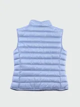 Chaleco acolchado Moncler modelo Liane, color celeste, con cierre frontal de botones a presión, cuello alto y logo de la marca aplicado en el pecho.