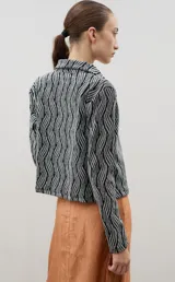 Camisa de encaje con diseño floral, de corte recto y manga larga, con cierre frontal de botones clásicos y cuello camisero.