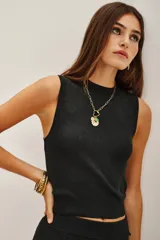 Top sin mangas de tejido de punto con acabado metalizado, corte al cuerpo y cuello redondo. Presenta un diseño minimalista con ajuste en la cintura.