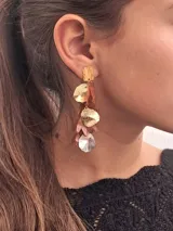 Aros colgantes de metal dorado con forma de pétalos de distintos colores.