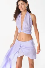 Top color blanco de lino italiano, con diseño de escote halter pronunciado, espalda descubierta y nudo frontal.
