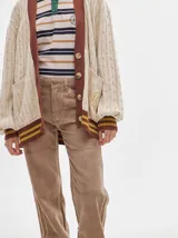 Pantalón de pana roja con corte holgado y tiro medio. Presenta una línea dorada a lo largo de la pierna.