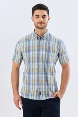 Camisa sport de manga corta con estampa a cuadros en tonos celestes, amarillos y blancos, con cuello camisero abotonado y bolsillo frontal en el pecho.