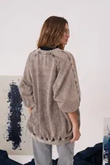 Buzo de calce oversized color gris con efecto desgastado, cuello redondo, mangas largas y estampa frontal con diseño cinematográfico.