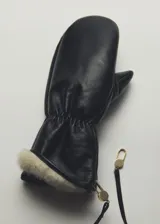 Guantes manoplas de cuero negro con forro de piel sintética en el puño y correa colgante con detalles metálicos dorados.