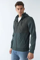 Campera de neopreno negra con capucha ajustable, cuello alto, bolsillos con cierre y logo en goma.