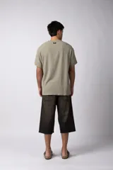 Remera de manga corta con cuello redondo, confeccionada en tejido de lino con textura entramada y corte holgado.