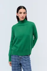 Polera tejida de punto confeccionada en lambswool color gris claro, con cuello alto y calce holgado.