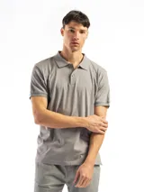 Remera tipo polo de manga corta, color blanco liso, con cuello de polo y tapeta de dos botones.