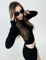 Camiseta negra de tejido texturizado, con cuello alto y mangas largas ajustadas.