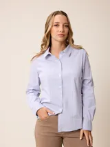 Camisa de corte clásico y calce entallado, color blanco, con cuello camisero, cierre frontal de botones y mangas largas con puños abotonados. Presenta un pequeño bordado distintivo en el pecho.