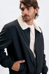 Campera tipo bomber color negro con cuello de corderito en color crema, cierre frontal y puños elásticos.