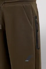 Pantalón jogger de entrenamiento, corte regular fit, color verde oliva oscuro. Confeccionado en tejido técnico compacto de algodón con elasticidad y efecto neopreno. Presenta cintura elástica ajustable con cordón blanco, bolsillos frontales y un bolsillo lateral con cierre de cremallera. El bajo termina en puño.