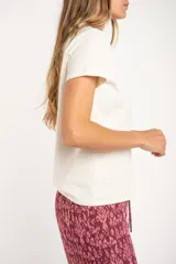 Remera de algodón peinado color blanco, con escote en V y detalles de lurex dorado en el borde del escote. De manga corta y corte ajustado.