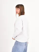 Buzo de cuello redondo en color gris melange, con estampa estilo universitario en tonos bordó y rosa en el frente.