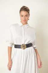 Cinturón plateado elástico con hebilla redonda metálica plateada.