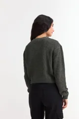 Sweater de punto con textura tipo waffle, color blanco, de corte clásico con cuello redondo y mangas largas.
