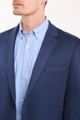 Saco azul oscuro de corte entallado, con solapa de muesca, cierre de dos botones, bolsillo de ribete en el pecho y bolsillos de parche en los laterales.