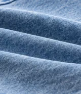Pantalón de jean corte slim, color azul claro con lavado stonewash, con cierre frontal de botón y cremallera, presillas para cinturón y bolsillos funcionales.
