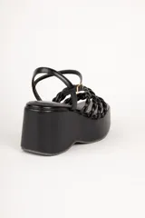 Sandalias de plataforma color blanco con tiras trenzadas y pulsera al tobillo.