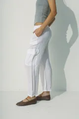 Pantalón de lino blanco, de corte recto y tiro alto, con bolsillos laterales y traseros.