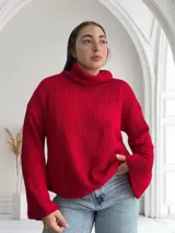 Sweater rojo de tejido de punto grueso con cuello alto y mangas largas.