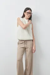 Pantalón de punto de corte relajado, con pierna recta y caída fluida. Presenta cintura con cordón ajustable y diseño minimalista.