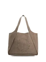 Cartera tipo tote bag Hush Puppies de color marrón, con diseño amplio y asas dobles para el hombro. Cuenta con perforaciones circulares en el frente formando un texto decorativo con la marca.