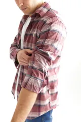 Camisa leñadora de algodón peinado a cuadros en tonos bordó, con cuello italiano y mangas largas.