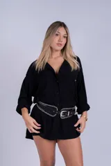 Camisa negra de mangas largas con botones y cinturón de cuero con tachas.