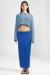 Falda larga azul de viscosa y poliamida, con detalle de cordones laterales con terminales metálicas color cobre.