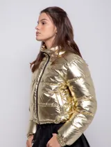 Campera puffer cropped metalizada color plateado, con cuello alto, cierre frontal, dos bolsillos laterales y elástico regulable en la cintura.